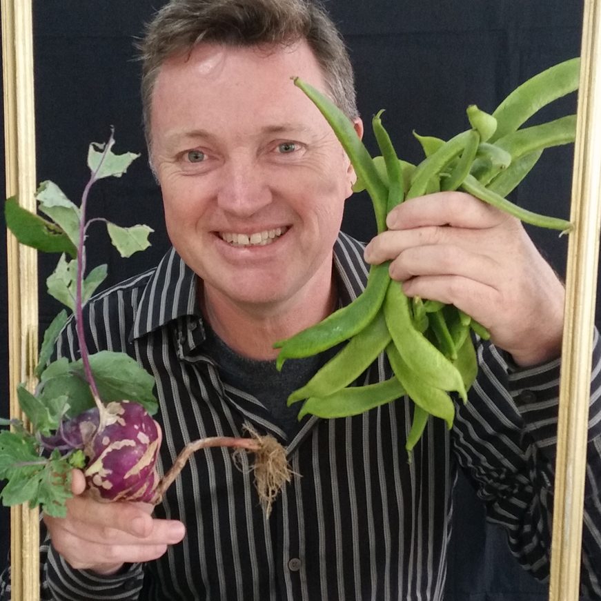 David smiling holding veg he has grown